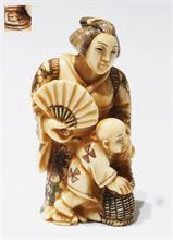 Netsuke,  kleine Schnitzfigurengruppe,  Japan. "Frau mit Fächer und Kind mit Korb".