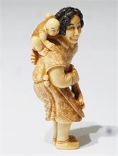 Netsuke,  kleine Schnitzfigurengruppe,  Japan. "Frau mit Posaune und Baby auf dem Rücken".