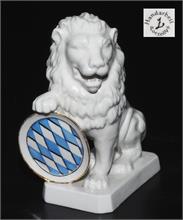 Sitzender Löwe auf flachem Rechtecksockel mit  blau-weißem Rautenschild